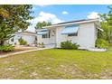 White brick house with blue awnings, a walkway, and a grassy yard at 330 45Th S St, St Petersburg, FL 33711