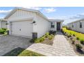 Tan house with a two-car garage and a walkway at 44197 Frontier Dr, Punta Gorda, FL 33982