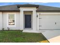 House exterior featuring a modern front door and garage at 8429 Malcolm Ave, North Port, FL 34287