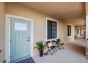 Condo entry with light teal door and small patio seating at 900 E Marion Ave # 1403, Punta Gorda, FL 33950