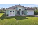 Newly built home with light green facade, tile roof, and well-manicured lawn at 1228 Eppinger Dr, Port Charlotte, FL 33953