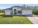 Single-story home with a light green exterior, tile roof, and paved driveway at 1228 Eppinger Dr, Port Charlotte, FL 33953