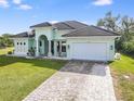 One-story house with a light green exterior, tile roof, and a paved driveway at 1228 Eppinger Dr, Port Charlotte, FL 33953