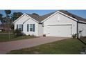 A well-maintained home features a brick driveway, complementing the attached two-car garage and manicured lawn at 16031 Alcira Cir, Punta Gorda, FL 33955