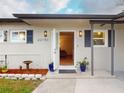 A welcoming view of the front door of the house with stylish sconces, and decorative plants in colorful pots at 22143 Lasalle Rd, Port Charlotte, FL 33952