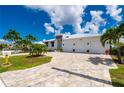 Charming home with a metal roof, a three-car garage, and a brick-paved driveway lined with palm trees at 2750 W Marion Ave, Punta Gorda, FL 33950
