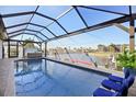Inviting screened-in pool area with comfortable lounge chairs and canal view at 2750 W Marion Ave, Punta Gorda, FL 33950