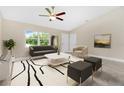 Spacious living room with gray sofa and a neutral color scheme at 4217 Winfall Ave, North Port, FL 34286