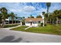 Single story home with a yellow exterior, red door, and lush lawn at 700 W Perry St, Englewood, FL 34223