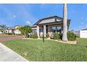 Landscaped front yard with palm tree, brick pavers, and home exterior at 15292 Mille Fiore Blvd, Port Charlotte, FL 33953