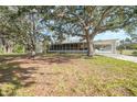 Ranch style home with screened porch and large shade trees at 1931 Bayshore Dr, Englewood, FL 34223