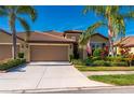 Charming home featuring a well-manicured lawn, beautiful landscaping, and a tile roof at 2427 Daisy Dr, North Port, FL 34289
