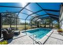 Inviting screened pool with patio furniture and lush landscaping at 24490 Wallaby Ln, Punta Gorda, FL 33955