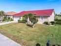 Charming home featuring a red roof, manicured landscaping, and a spacious front yard at 3818 Bordeaux Dr, Punta Gorda, FL 33950