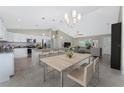 Open kitchen and dining area with stainless appliances, island seating, and modern lighting at 5587 E Price Blvd, North Port, FL 34288