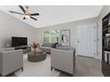 Bright living room features a ceiling fan, neutral color palette, and elegant furnishings at 5587 E Price Blvd, North Port, FL 34288