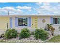 House exterior featuring a yellow door and purple accents at 817 E 6Th St, Englewood, FL 34223