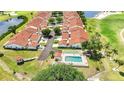 Aerial view showcasing the community featuring a pool, mature trees, and sidewalks with red tile roofs at 1640 Atares Dr # 6, Punta Gorda, FL 33950