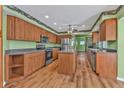 Traditional kitchen with wood cabinets, center island, laminate flooring, and stainless steel appliances at 4107 Rock Creek Dr, Port Charlotte, FL 33948