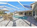 Screened-in pool with a patio table, lounge chairs, and ample seating on a sunny day at 4107 Rock Creek Dr, Port Charlotte, FL 33948