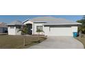 Beautiful home showcasing a spacious driveway, lush lawn, and charming curb appeal at 17220 Horizon Ln, Port Charlotte, FL 33948
