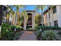 Charming courtyard entrance with lush landscaping and brick pathway leads to residences at 23465 Harborview Rd # 1006, Punta Gorda, FL 33980