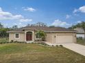 Charming single-story home with a well-manicured lawn, driveway, and attached two-car garage at 4557 Sabrina Ter, North Port, FL 34286