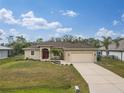 Charming single-story home with a well-manicured lawn, a driveway, and a two-car garage at 4557 Sabrina Ter, North Port, FL 34286