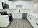 Modern kitchen with white cabinetry, stainless steel appliances and hard surface counters at 1100 Belkton Ave, Port Charlotte, FL 33948