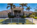 Inviting home with a grand entrance, well-manicured lawn, lush landscaping, and circular driveway with great curb appeal at 17557 Ohara Dr, Port Charlotte, FL 33948