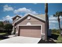 Side view of a two-story house with a well-maintained lawn and a two-car garage at 5275 Layton Dr, Venice, FL 34293