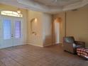 Spacious living room featuring tile flooring, double door entry, and recessed alcove at 1057 Staley St, Port Charlotte, FL 33952