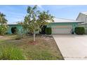 Charming single-story home featuring a well-maintained front yard, two-car garage, and beautiful turquoise exterior at 1845 Edison Dr, Englewood, FL 34224