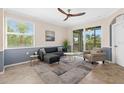 Comfortable living room boasts tiled floors, contemporary furniture, large windows, and access to outdoor balcony at 14091 Heritage Landing Blvd # 121, Punta Gorda, FL 33955