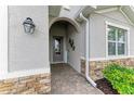 Charming front entrance with stone accents, arched entry, and stylish welcome sign at 15169 Spanish Point Dr, Port Charlotte, FL 33981