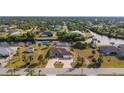 Aerial view of a waterfront property with a circular driveway and a backyard pool at 4122 Library St, Port Charlotte, FL 33948