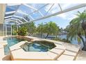 A screened-in outdoor spa is positioned next to a canal at 3663 Whippoorwill Blvd, Punta Gorda, FL 33950