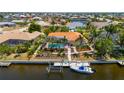 Aerial shot of the property featuring its private boat dock and pool, surrounded by tropical landscaping and water access at 805 Brenda Ct, Punta Gorda, FL 33950