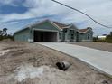 New construction home featuring a concrete driveway, a two-car garage, and neutral-colored exterior paint at 8599 Waldrep St, Port Charlotte, FL 33981