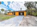 Charming home featuring an open carport, a long driveway and lush tropical landscaping at 201 Winson Ave, Englewood, FL 34223