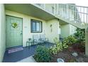 Inviting condo porch with seating, a decorative front door, and lush landscaping at 25225 Rampart Blvd # 1701, Punta Gorda, FL 33983