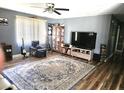 Spacious living room with a large rug, ceiling fan, and entertainment center at 1174 Victoria Ave, Port Charlotte, FL 33948