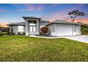 Elegant single-story home with a three-car garage under a beautiful sunset sky at 2137 Onondaga Ln, Punta Gorda, FL 33983