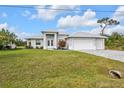 Charming single-story home with lush green lawn, three car garage, and well-maintained landscaping at 2137 Onondaga Ln, Punta Gorda, FL 33983