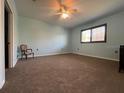Large bedroom offers ample space with neutral carpeting and a ceiling fan at 24157 Green Heron Dr # 27, Punta Gorda, FL 33980