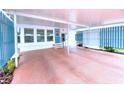 Spacious carport with painted floor and decorative privacy fence and entry to the home at 6642 Acacia Ct, North Port, FL 34287