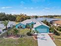 Charming blue single-story home with mature landscaping, an attached garage, and a serene lake view at 2275 Kenya Ln, Punta Gorda, FL 33983