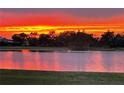 Vibrant sunset reflects off the calm lake, creating a serene and picturesque scene at 2275 Kenya Ln, Punta Gorda, FL 33983