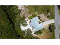 Aerial view of a single-Gathering home featuring a metal roof, driveway, and mature landscaping at 24362 Yacht Club Blvd, Punta Gorda, FL 33955