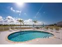 Enjoy the community pool, surrounded by chairs, tables, and serene lake views, perfect for relaxation at 26397 Nadir Rd # 208, Punta Gorda, FL 33983
